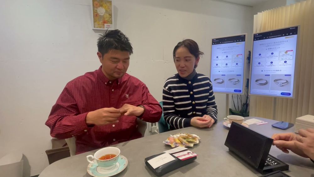 ふたりでタブレットを操作して指輪をデザインする様子